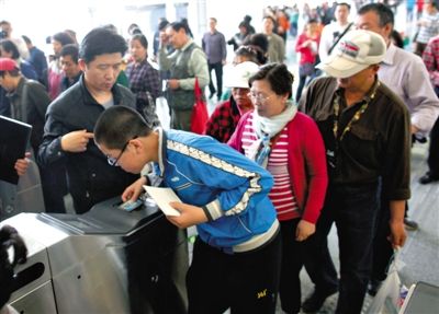 去年5月5日，14号线园博园站，乘客刷卡出地铁。北京公交地铁将实行计程票制，多乘坐多付费。新京报记者 薛珺 摄