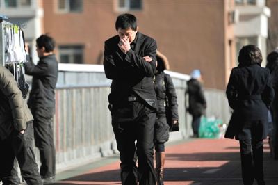 12月1日，北风呼啸，一名男子走在街头，刺骨的寒风让他赶忙裹紧外衣。图/东方IC